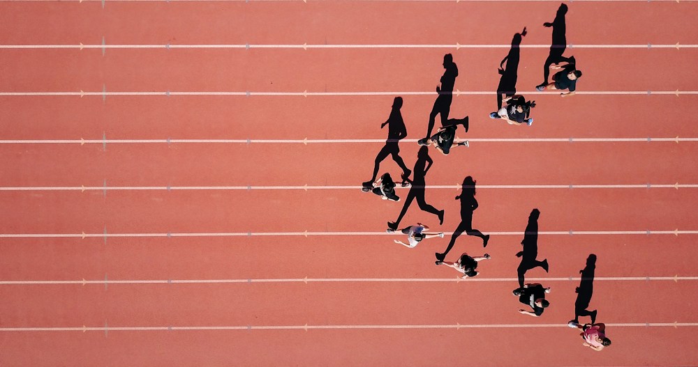 Vista aérea de corredores e suas sombras em uma pista